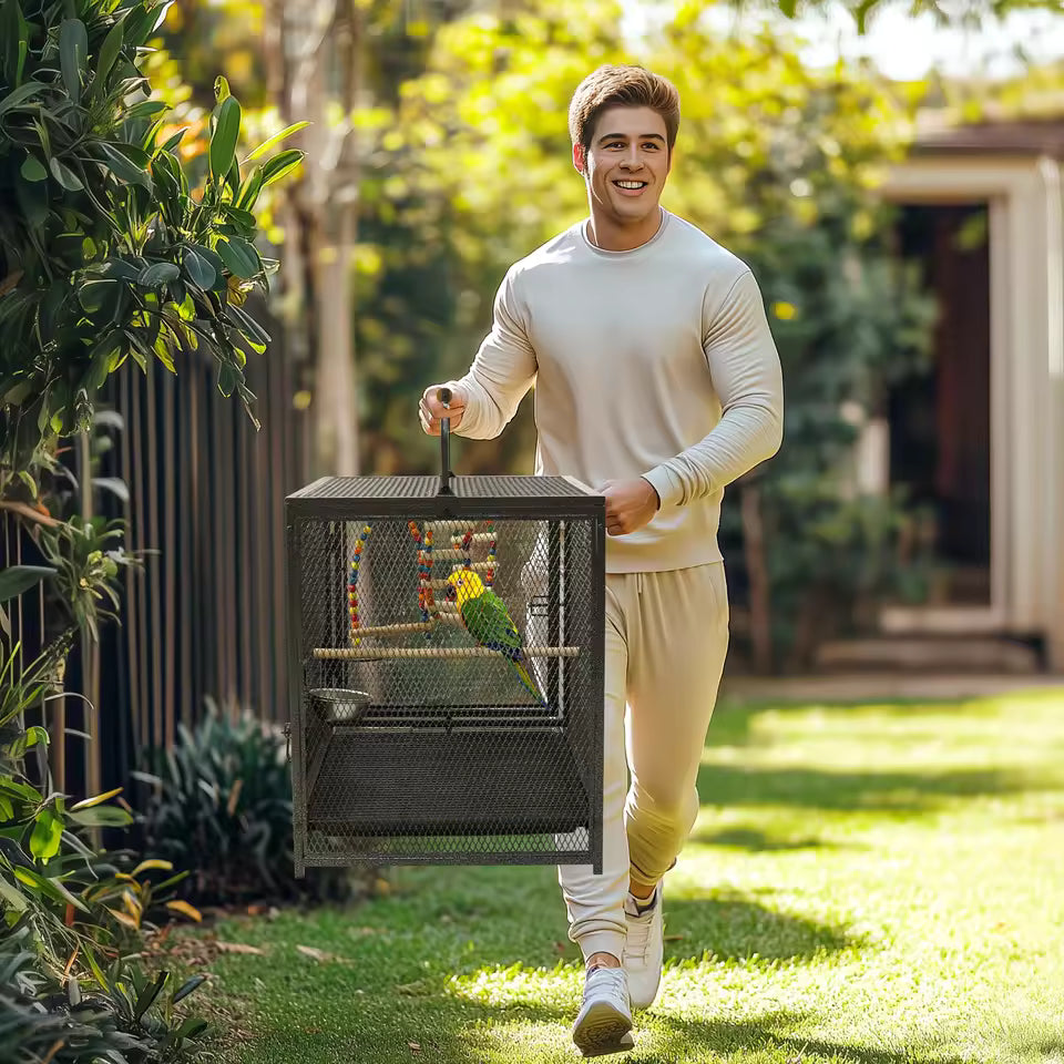 A man walking outdoors while carrying a metal bird cage with a parrot inside.