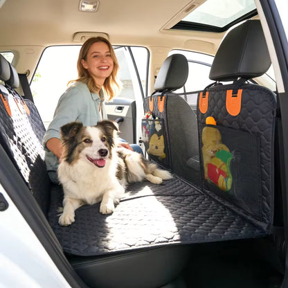 A happy dog and smiling woman sitting on a black quilted car seat protector with mesh pockets.