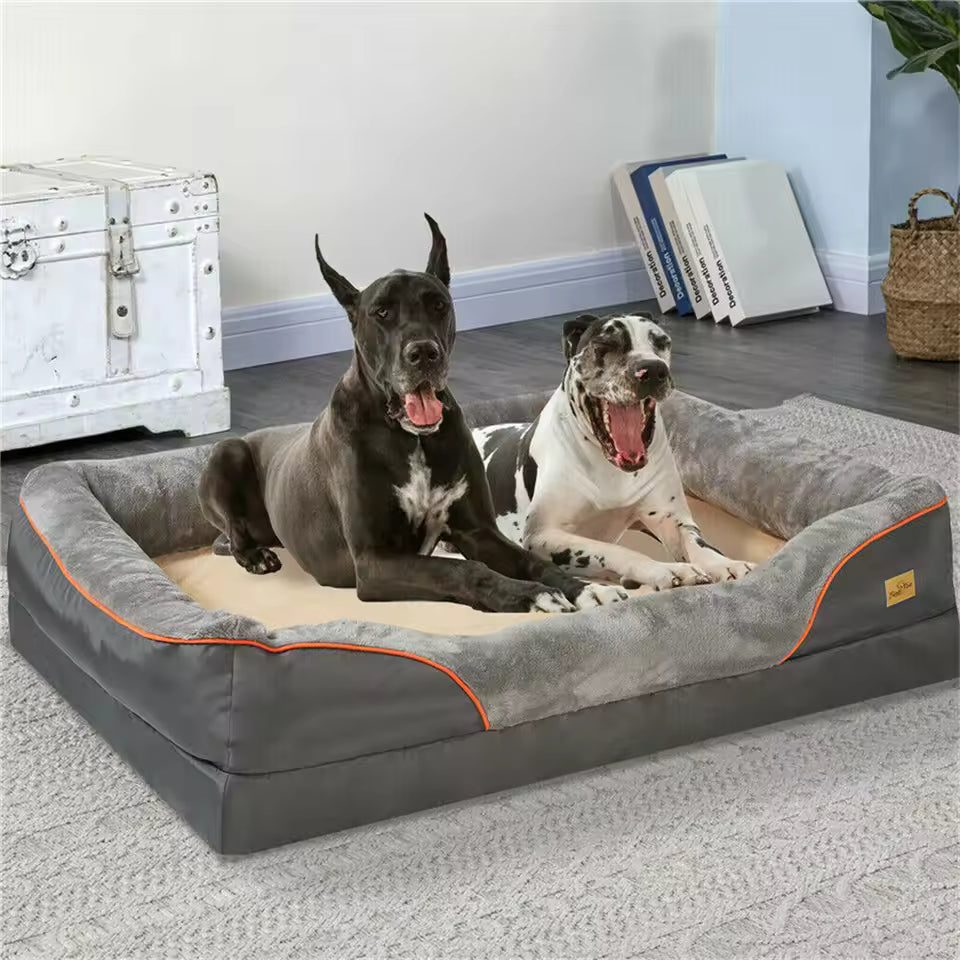 Two large Great Dane dogs resting together inside a spacious gray and tan orthopedic pet bolster couch.