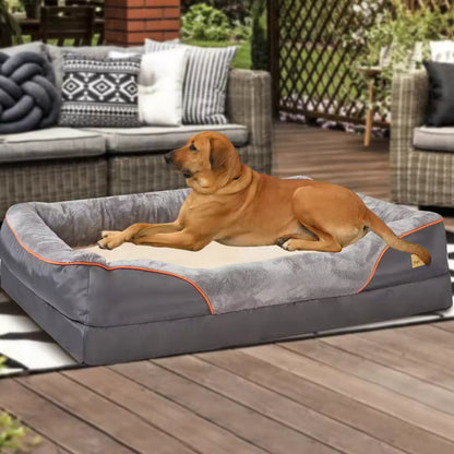 A brown dog resting on a large gray and tan orthopedic pet bolster couch on an outdoor patio.