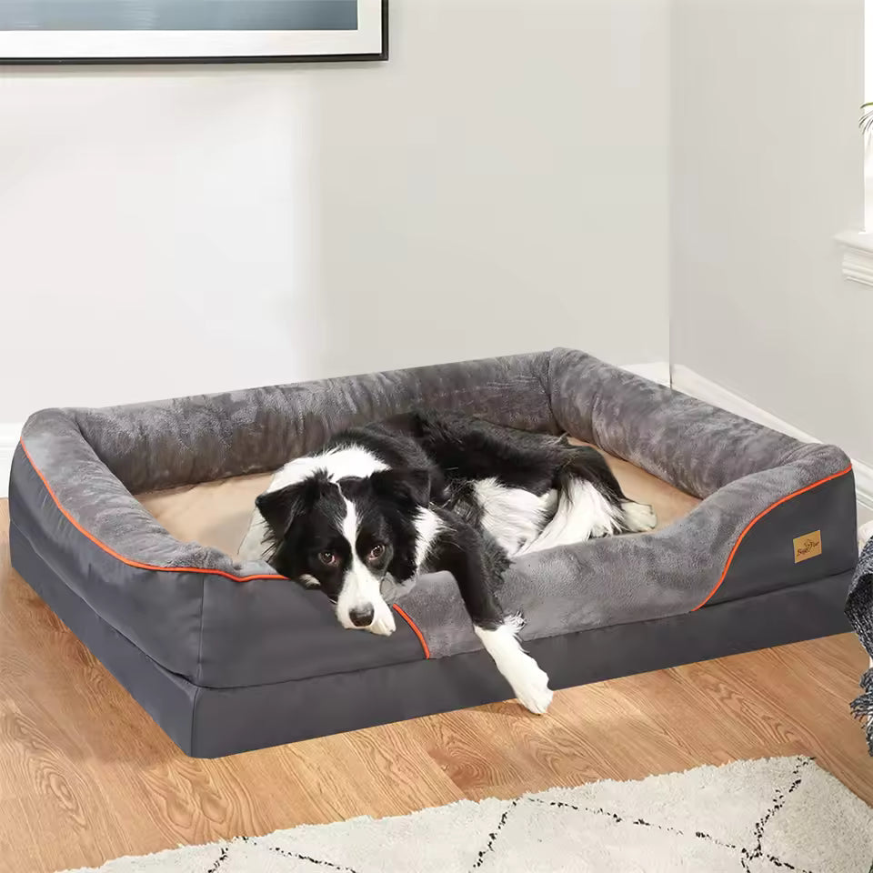 A black and white dog resting inside a large gray and tan orthopedic pet bolster couch.