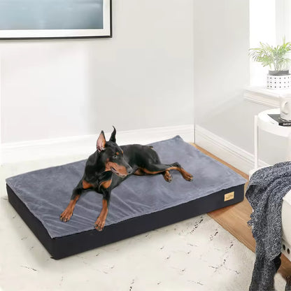 A Doberman resting on a large grey pet bed indoors.