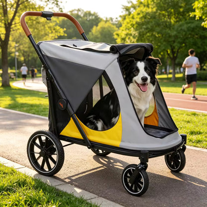 A black and white dog sits inside a grey, yellow, and black pet stroller on a park path.