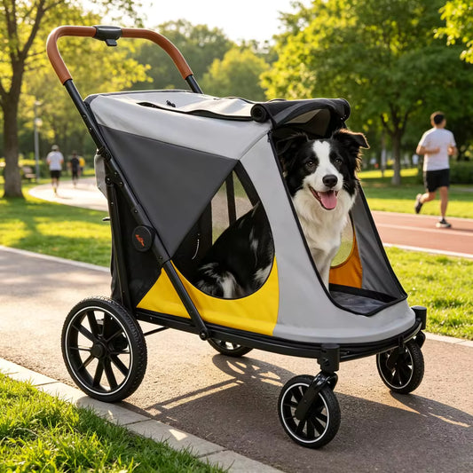 A black and white dog sits inside a grey, yellow, and black pet stroller on a park path.