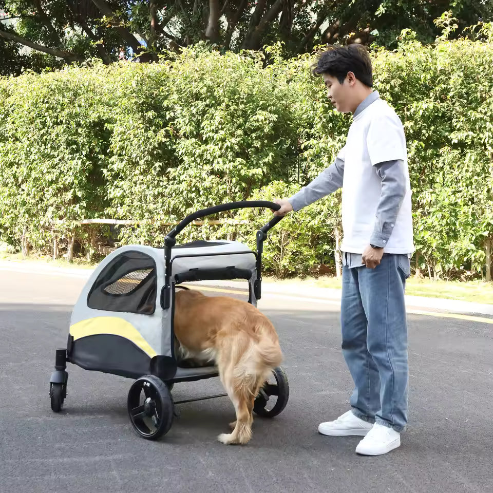 Golden Retriever stepping out of a gray and yellow pet stroller while a person stands nearby outdoors.