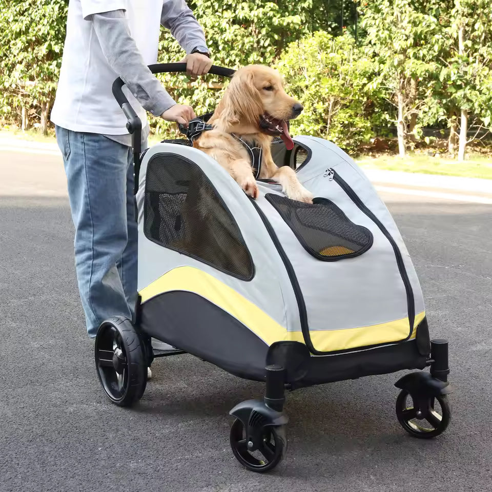Golden Retriever sitting in a gray and yellow pet stroller with its front paws resting on the edge outdoors.
